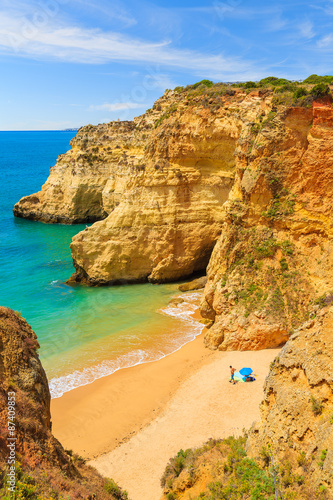 People sunbathing on beautiful beach near Portimao town, Algarve region, Portugal
