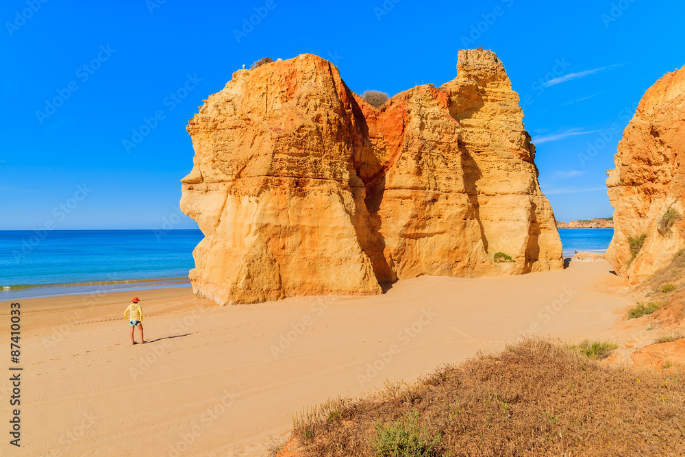 Tourist standing on beautiful Praia da Rocha beach, Algarve region, Portugal