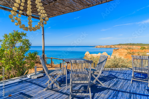 Tables with chairs of restaurant on coast of Portugal near Portimao town, Algarve region