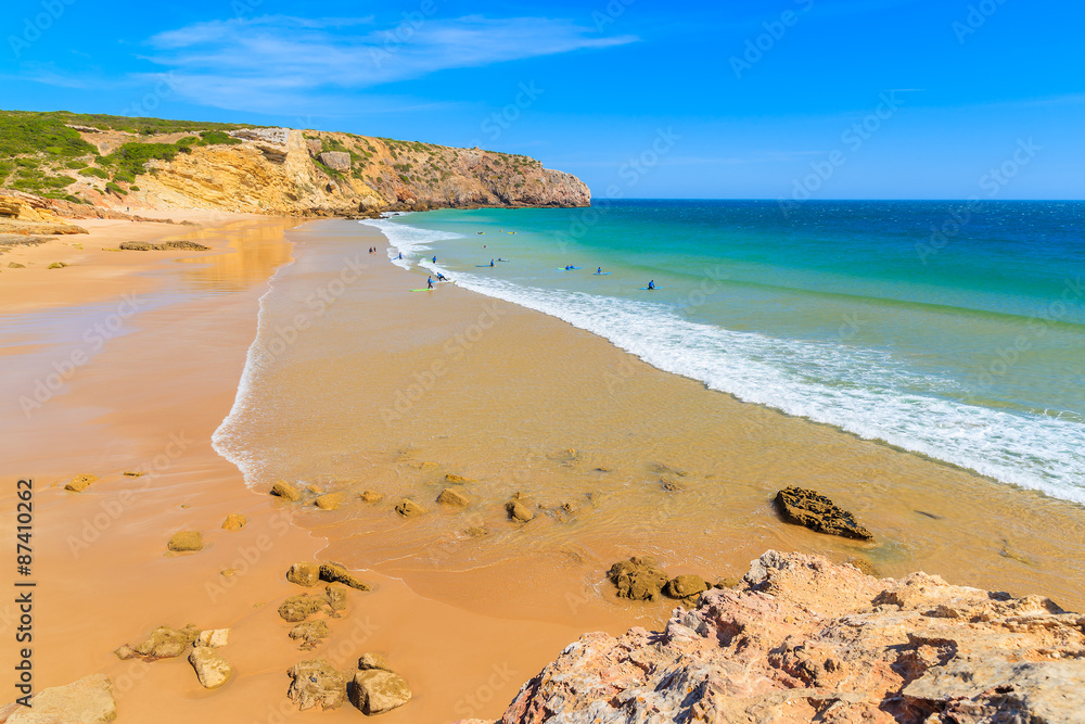 Surfers on Praia do Zavial beach with turquoise sea water, Algarve region, Portugal Surfers on Praia do Zavial beach with turquoise sea water, Algarve region, Portugal