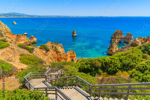 Wooden footbridge walkway to beautiful beach Praia do Camilo on coast of Algarve region, Portugal