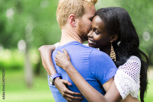 Couple in love hugging and kissing peacfully outdoors