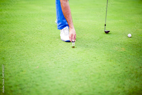 Картината върху платно Golf player repairing divot