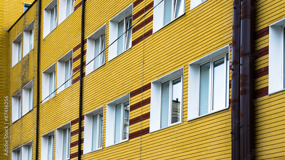 Many windows in yellow brick building