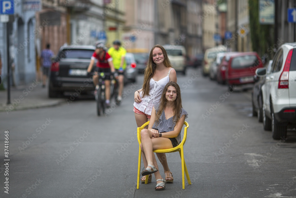 Two young best girlfriends in the old European town, conceptual photo about the vacation.