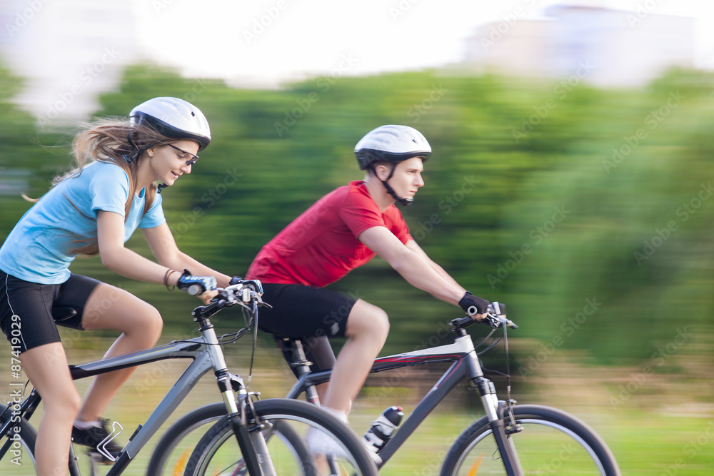 Cycling Concept: Young Caucasian Couple Having a Speedy Bicycle Cycling Concept: Young Caucasian Couple Having a Speedy Bicycle