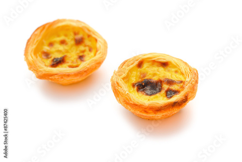 two single portuguese egg tarts on a white background photo