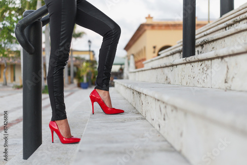 Lady in red high heel shoes walking up the stairs