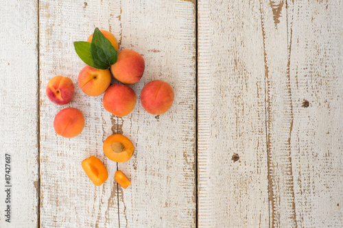 Fresh homegrown apricots on vintage white wooden table, view from above