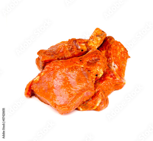 The pieces of meat in the marinade on a white
