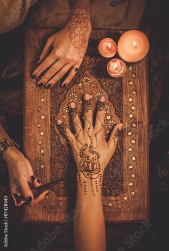 Fotografie Drawing process of henna menhdi ornament on woman's hand