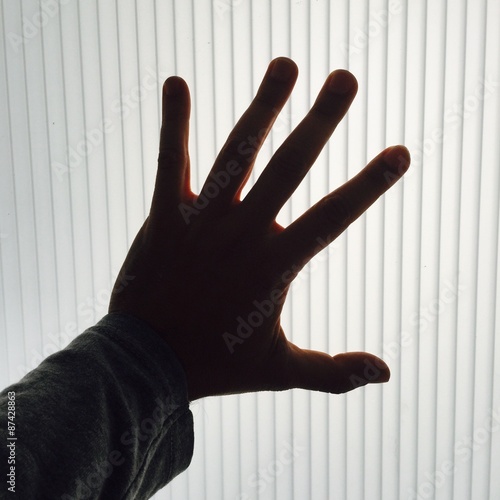 Mano sobre cristal a contraluz