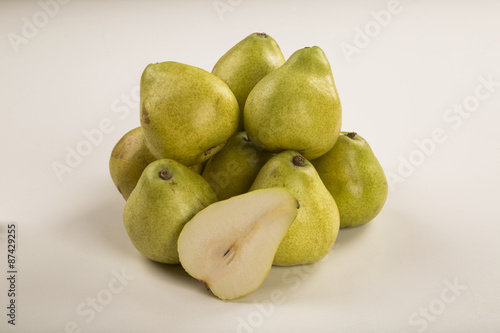 Some pears in a basket over a wooden surface seen from above