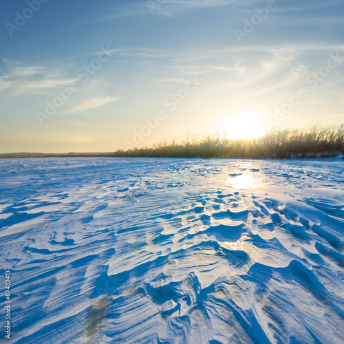 winter snowbound plain at the sunset