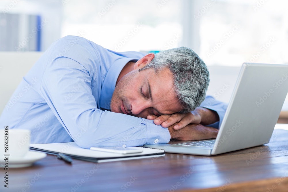 Businessman sleeping on laptop computer Businessman sleeping on laptop computer