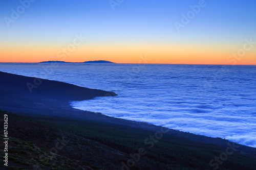 Aerial view over clouds above ocean water with last sunshine, Tenerife, Canary Islands, Spain