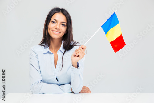 Papier peint Woman sitting at the table with romanian flag