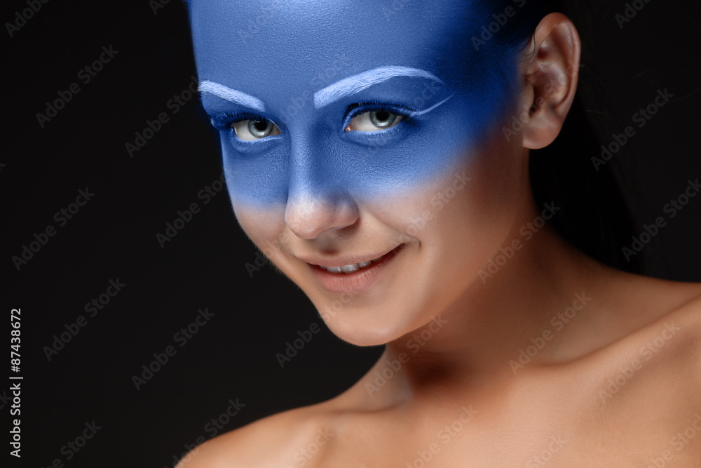 Portrait of a woman who is posing covered with blue paint
