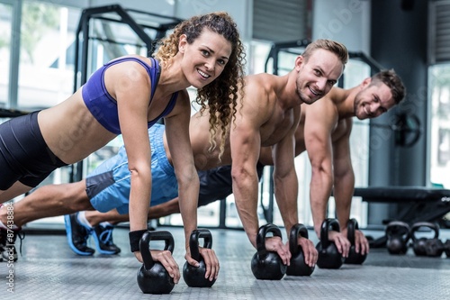 Three muscular athletes on a plank position