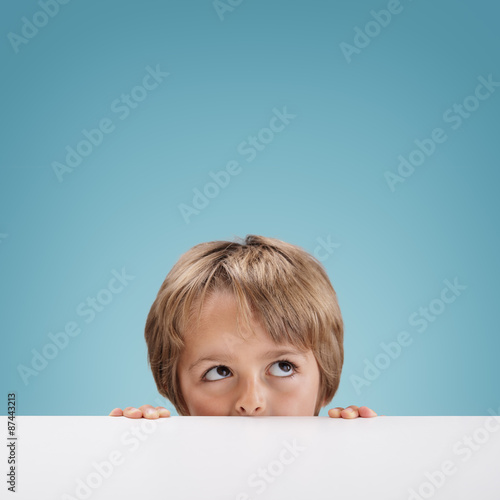 фотографія Boy peeking over a white board