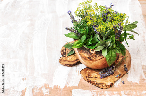 Bouquet of fresh herbs and olive wood kithchen tools. Healthy fo