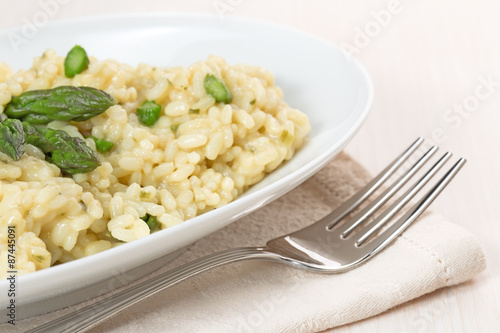 risotto dish with asparagus and fork on beige napkin