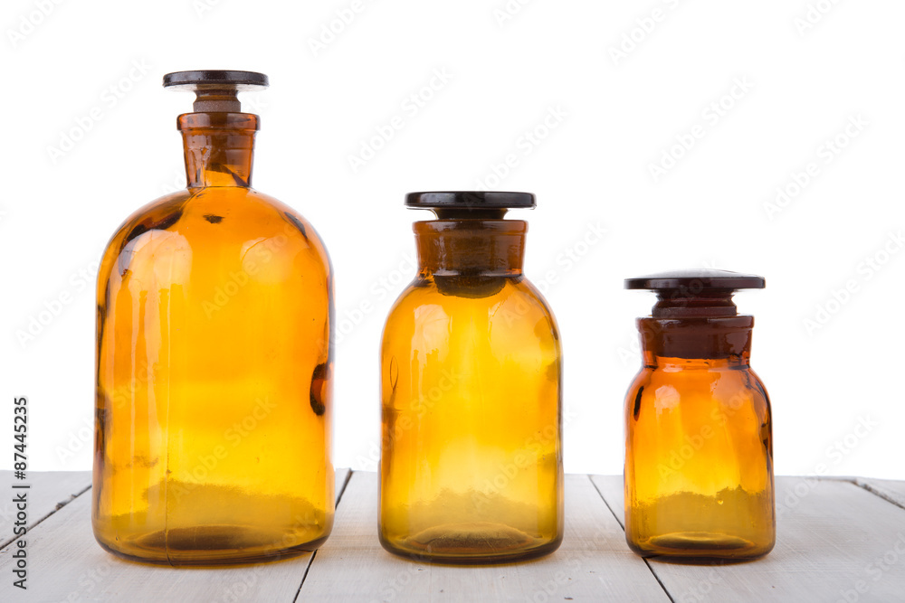 Vintage medicine bottles on wooden table isolated on white