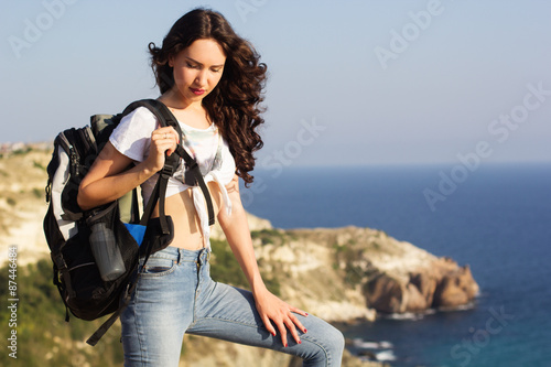 Girl traveler is standing on rock with backpack © _chupacabra_