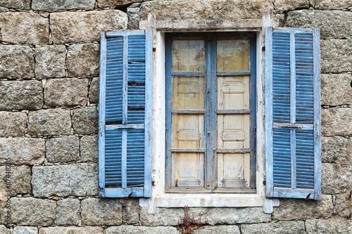 Old window with blue open shutters