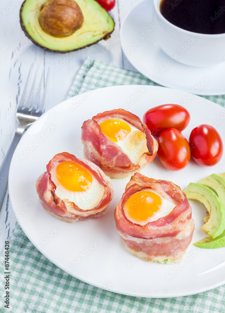 Baked eggs with avocado in bacon cups for breakfast Baked eggs with avocado in bacon cups for breakfast