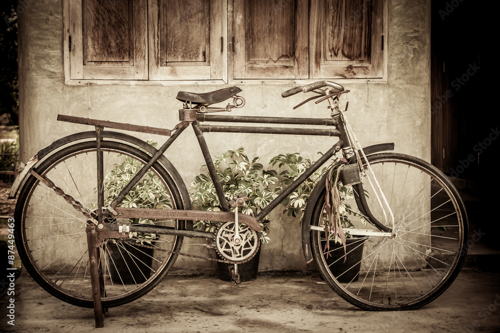 Old bicycle on wooden window house wall in vintage color tone Old bicycle on wooden window house wall in vintage color tone