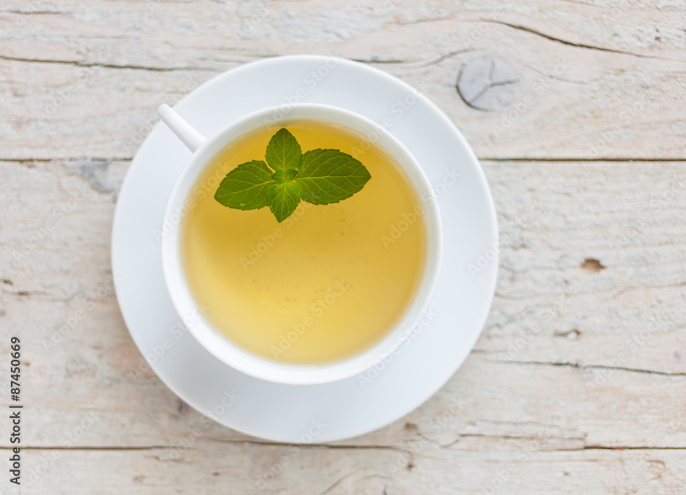 A cup of green tea on the wooden background A cup of green tea on the wooden background