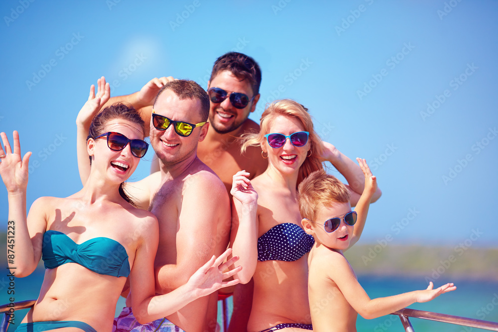 group of happy friends, family having fun on yacht, during summer vacation