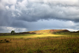 Stunning view to savanna under stormy cloudy sky with single bright patch of sunlight 