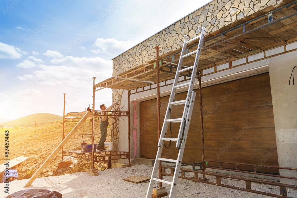 Obraz premium Man putting natural stones on a wall