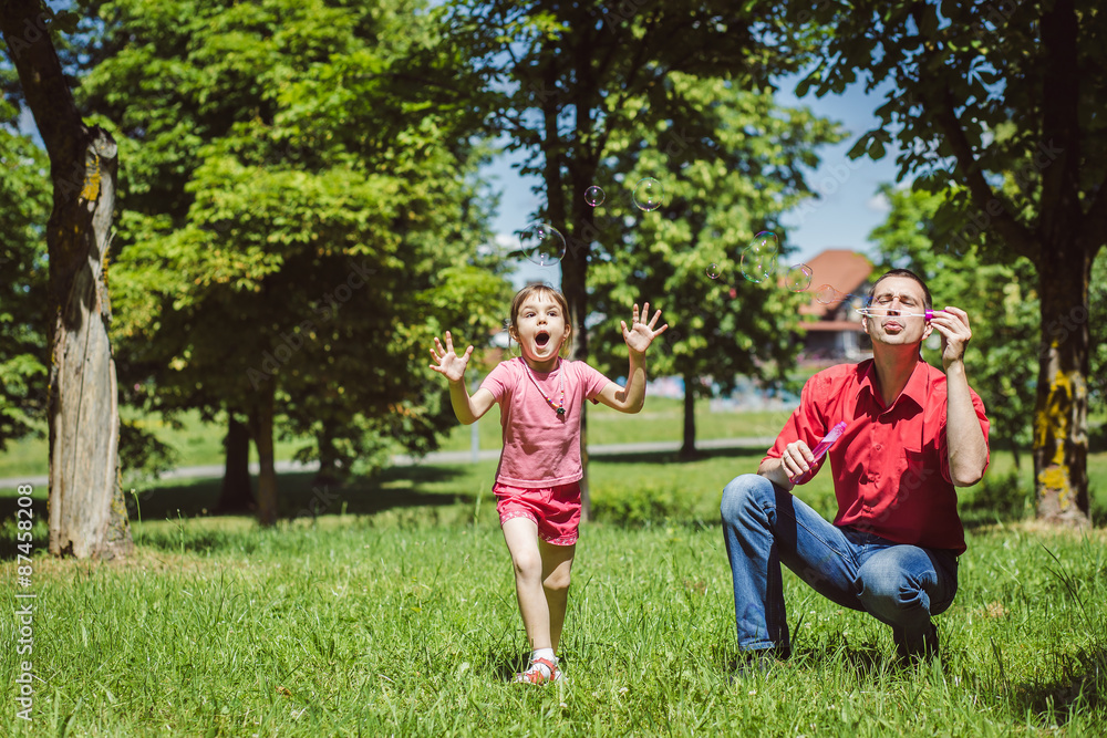 Fototapeta premium Dad and his daughter are making bubbles
