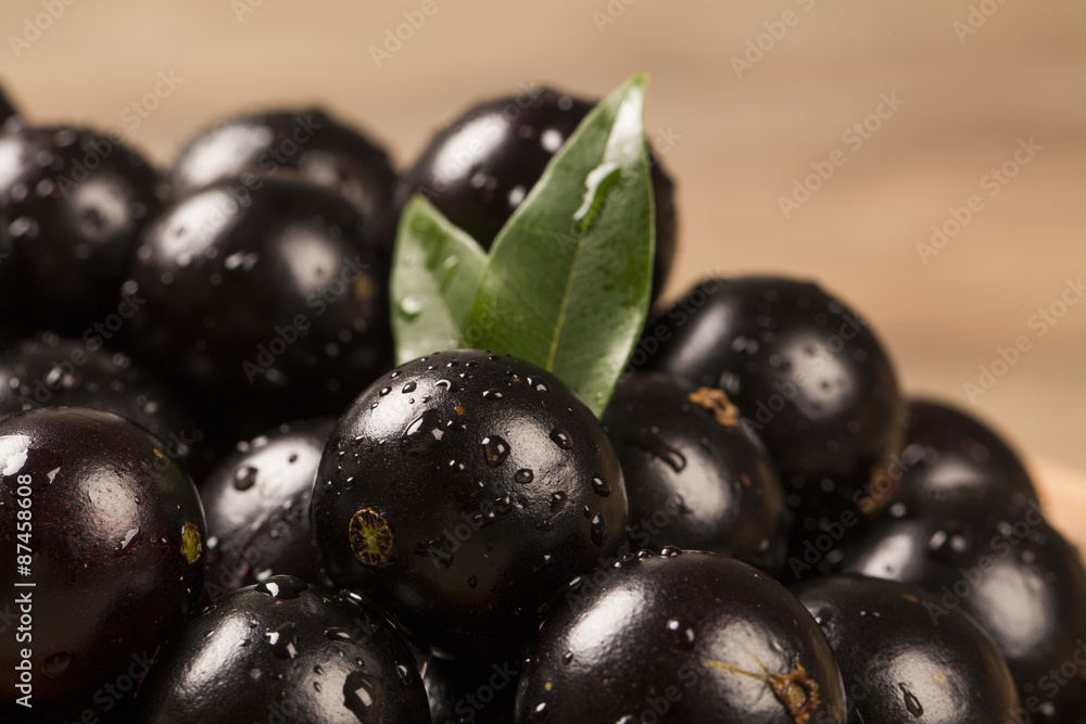 Berry Jaboticaba in bowl on wooden table Berry Jaboticaba in bowl on wooden table