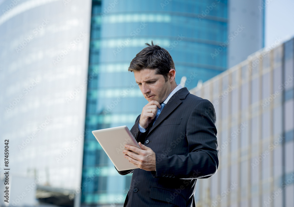 businessman holding digital tablet standing outdoors working outdoors