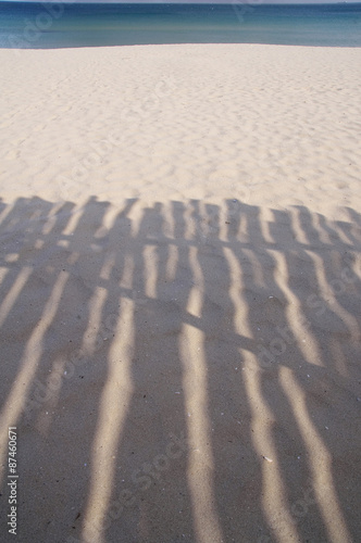Shadow of wooden shelter on the beach near
