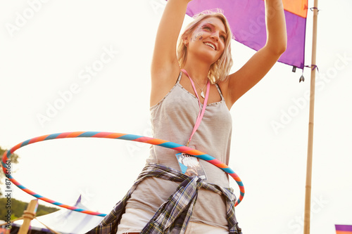 Blonde woman dancing with hula hoop at a music festival photo