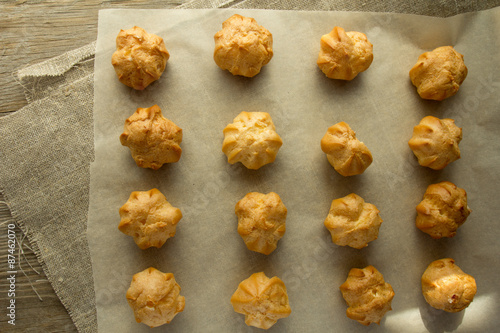 Profiteroles on cooking paper top view