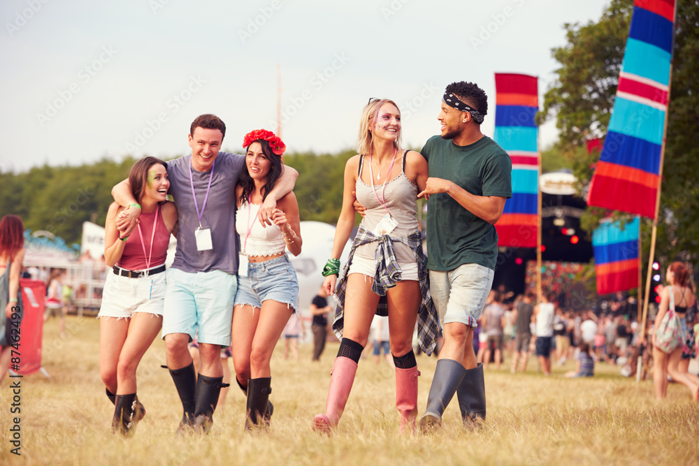 Friends walking through a music festival site Friends walking through a music festival site