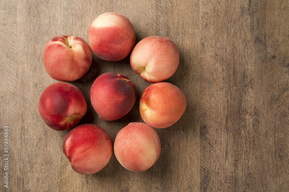 Some peaches in a basket over a wooden surface Some peaches in a basket over a wooden surface