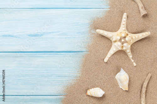 Sea sand with starfish and shells on wood