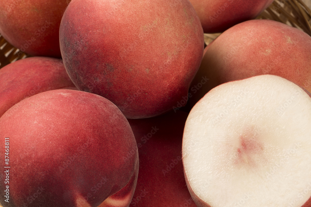 Some peaches in a basket over a wooden surface Some peaches in a basket over a wooden surface