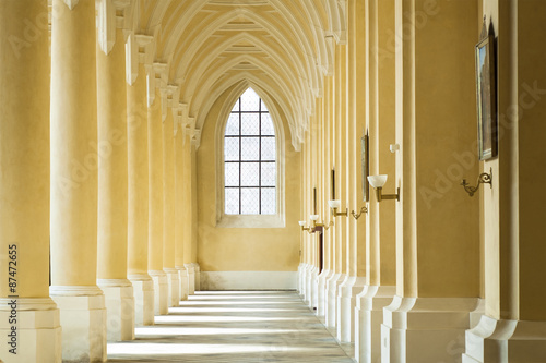 Colonnade with shadows of columns in the church. Prague