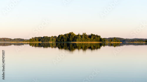 symmetric reflections on calm lake © Martins Vanags