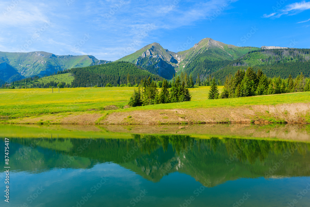 Mountain peaks reflection in water of a lake in summer landscape of Tatra Mountains, Slovakia Mountain peaks reflection in water of a lake in summer landscape of Tatra Mountains, Slovakia