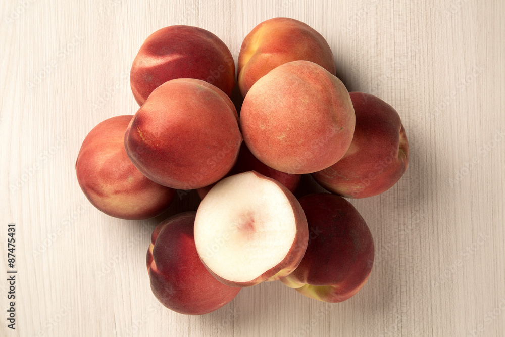 Obraz premium Some peaches in a basket over a white background