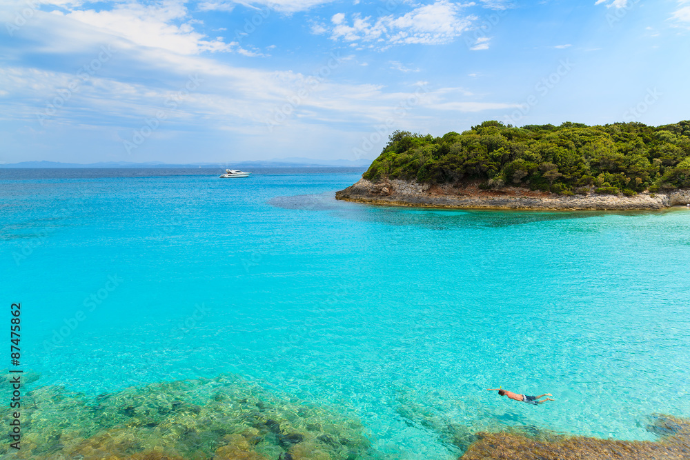 Man snorkeling in turquoise sea water of Petit Sperone bay, Corsica island, France